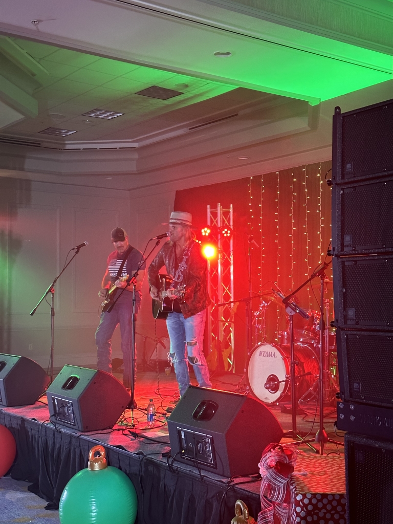 Live music performance featuring musicians on stage with colorful lights at an event in Panama City, FL. Neves Media captures local events.
